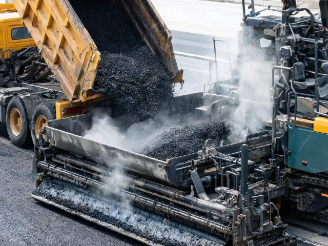 Asphalt paver screed and hopper on paving site